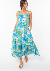 [Color: Green/Aqua] A model wearing a flowy bohemian maxi tank dress in a bright green and blue retro floral print. 