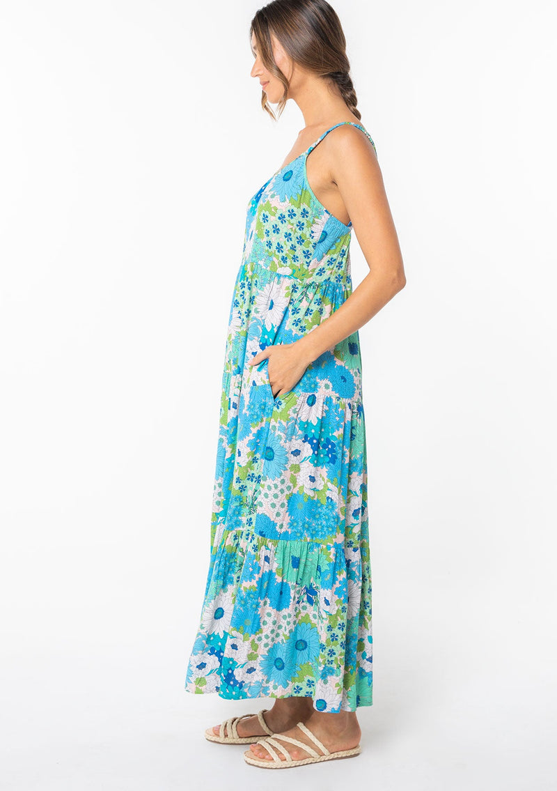 [Color: Green/Aqua] A model wearing a flowy bohemian maxi tank dress in a bright green and blue retro floral print. 