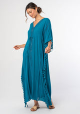 [Color: Teal] A woman wearing a sheer teal bohemian beach cover up maxi dress with lace and tassel trim and side slits. A kimono kaftan maxi dress perfect for vacations! 