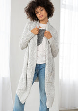 [Color: Silver/Ivory] A model wearing a silver grey knit reversible cardigan. With long sleeves, a waterfall open front, side pockets, and a shawl collar. 