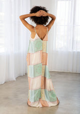 [Color: Natural/Mint] A model wearing a sleeveless patchwork paisley maxi dress. With a deep v neckline in front and back, adjustable spaghetti straps, and side pockets.