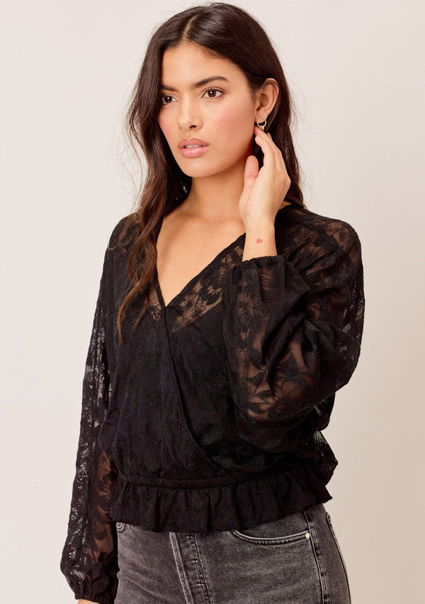 [Color: Black] A surplice front blouse in a floral embroidered lace. Featuring flattering voluminous dolman sleeves, a relaxed silhouette, and a flirty ruffled hemline. 