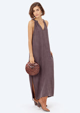 [Color: Charcoal] A brunette model wearing a cupro maxi dress with a split v-neckline, side pockets, and side slits. 