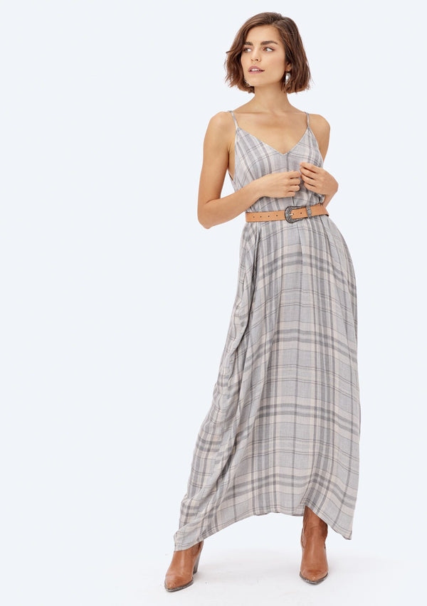 [Color: Grey/Vanilla/Gold] A blond woman in a field wearing a yarn dye plaid maxi dress. Featuring side pockets, a sexy v neckline in front and back, a billowy silhouette, and beautiful plaid with subtle metallic lurex details.