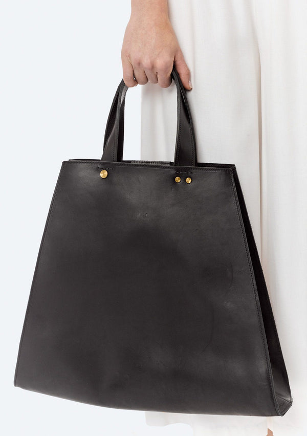 [Color: Nero] A black collapsible leather tote with short handles and a triangular or square silhouette. 