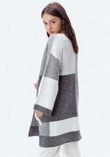 [Color: Heather Grey/Ivory] A side facing image of a brunette model wearing an ultra cozy color block cardigan in grey. Featuring wide long sleeves, dropped shoulders, an open front, and rib accents throughout. Perfect for Fall layering. 