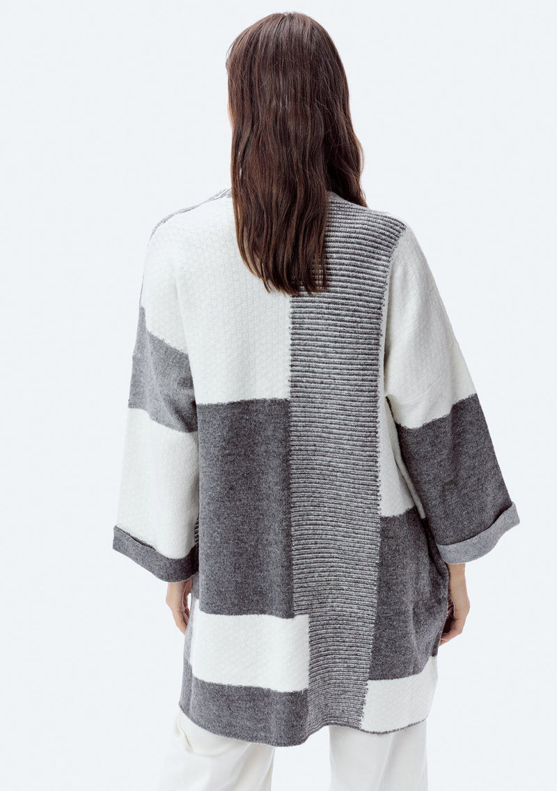 [Color: Heather Grey/Ivory] A back image of a brunette model wearing an ultra cozy color block cardigan in grey. Featuring wide long sleeves, dropped shoulders, an open front, and rib accents throughout. Perfect for Fall layering. 