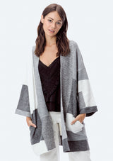 [Color: Heather Grey/Ivory] A brunette model wearing an ultra cozy color block cardigan in grey. Featuring wide long sleeves, dropped shoulders, an open front, and rib accents throughout. Perfect for Fall layering. 