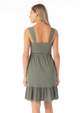 [Color: Olive] A back facing image of a blonde model wearing an olive green sleeveless spring mini dress. With wide tank top straps, a square neckline, a smocked slim fit bodice, an empire waist, and a ruffle trimmed tiered skirt.