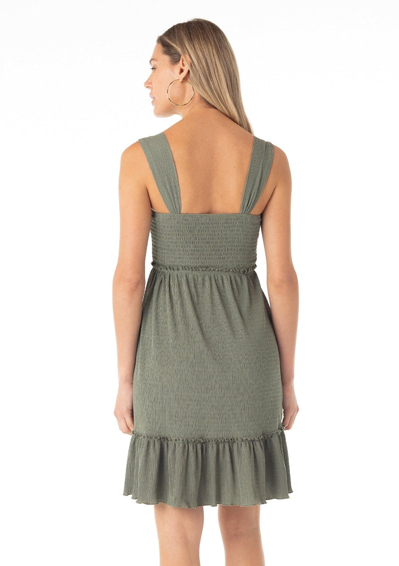 [Color: Olive] A back facing image of a blonde model wearing an olive green sleeveless spring mini dress. With wide tank top straps, a square neckline, a smocked slim fit bodice, an empire waist, and a ruffle trimmed tiered skirt.