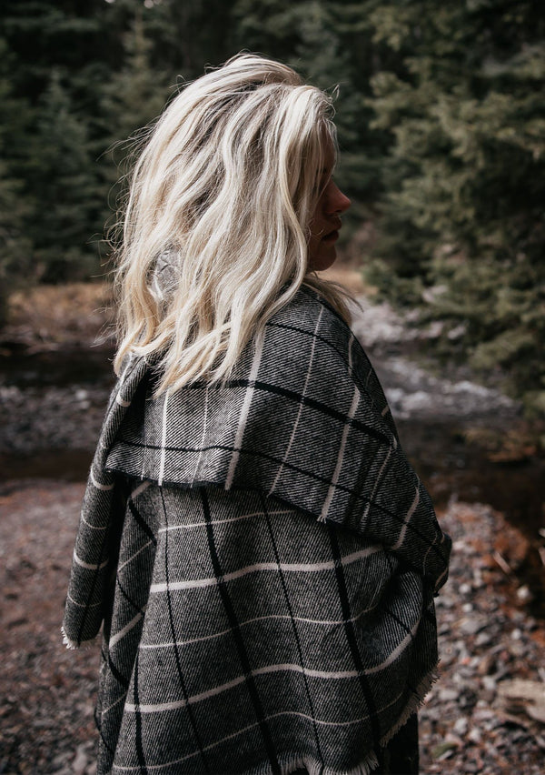 [Color: Black/Grey] Wrap yourself up in this cozy, oversized plaid scarf wrap with mini fringe trim. A classic style that pairs effortlessly with everything.