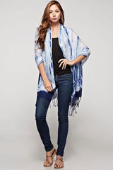 [Color: Indigo] A brunette model wearing a blue tie-dye bohemian scarf that can be styled as a sarong for the beach and draped as a scarf for a chic, cozy look.