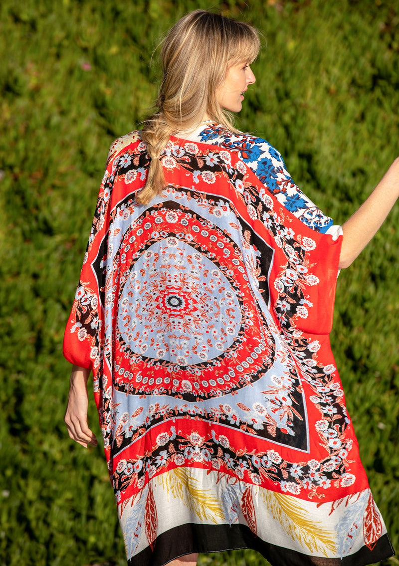 [Color: Red/Cloud] A model wearing a stunning mid length kimono in a red mixed floral print. Featuring half length kimono sleeves, side slits, and an open front.